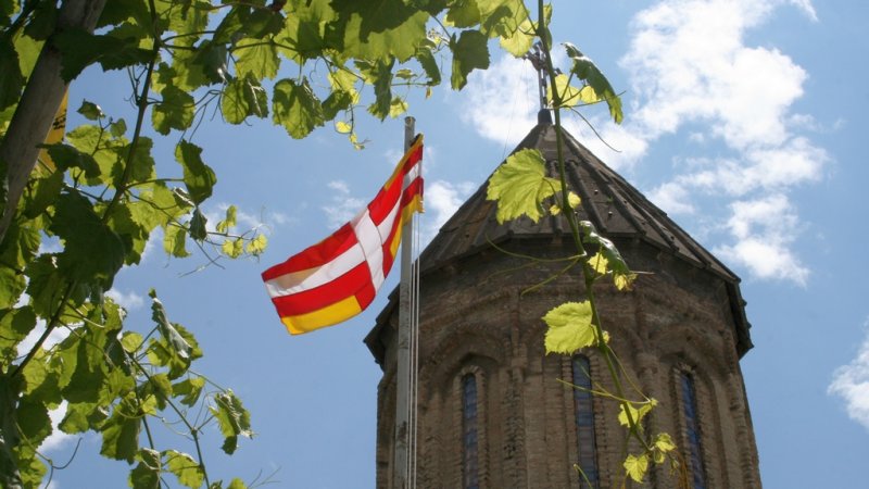 Развевающийся флаг на фоне церкви. Фото Ланы Парастаевой